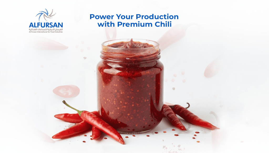 Al Fursan Premium Chili Production A glass jar of vibrant red chili paste surrounded by fresh whole red chili peppers and scattered seeds. The Alfursan International for Food Industries logo is in the top left, with the headline "Power Your Production with Premium Chili" centered at the top.