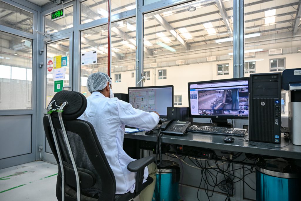 Quality control specialist monitoring fruit processing operations through advanced control systems at Al Fursan International for Food Industries.